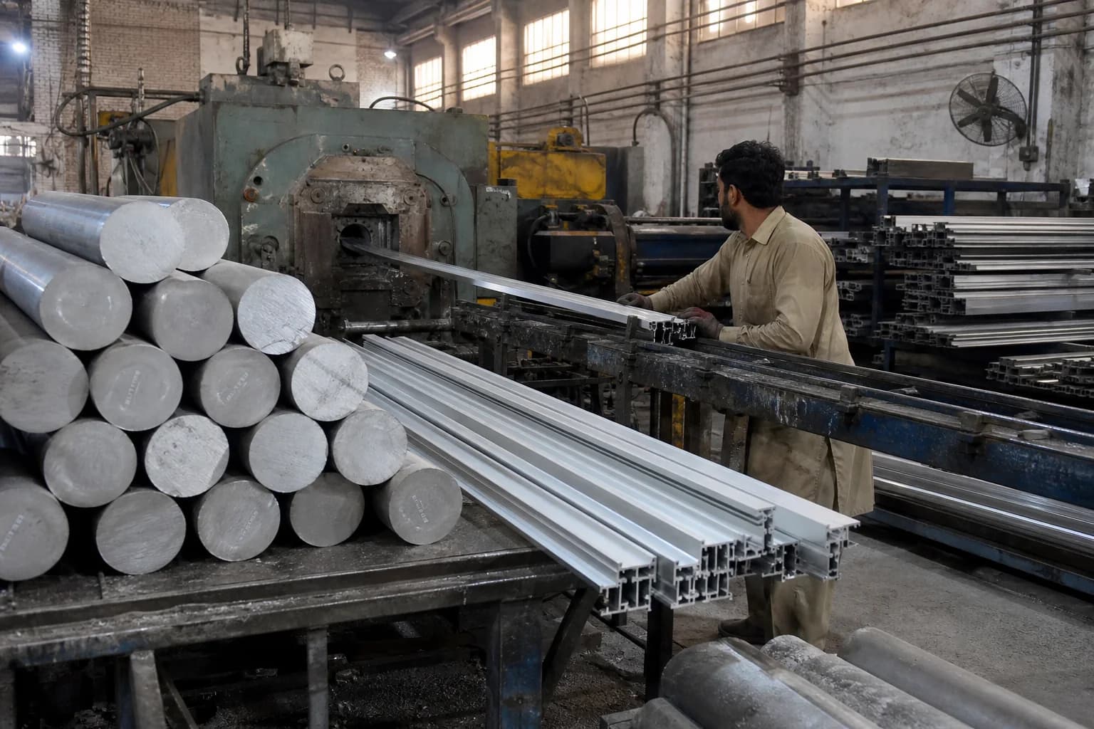Aluminium billet and profiles moving through a conventional extrusion plant