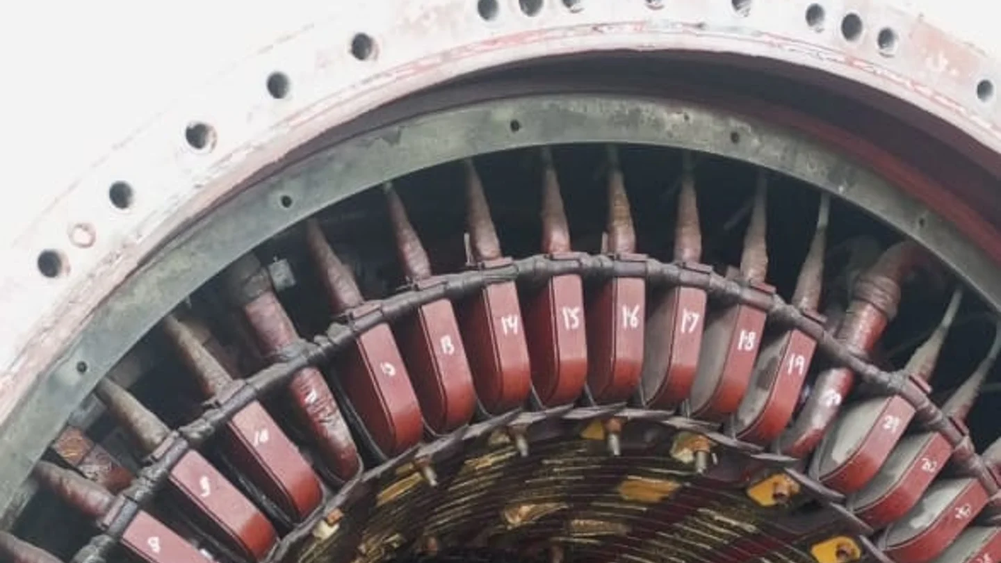 Generator stator core opened to show numbered copper armature windings seated in the slots