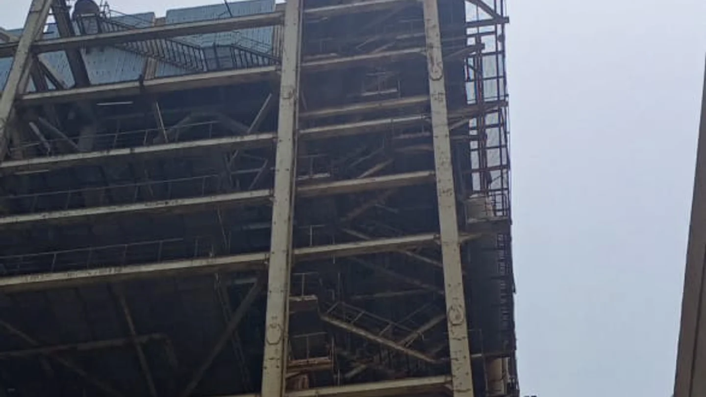 Multi-storey mild steel boiler house structure with stair towers and access walkways still standing