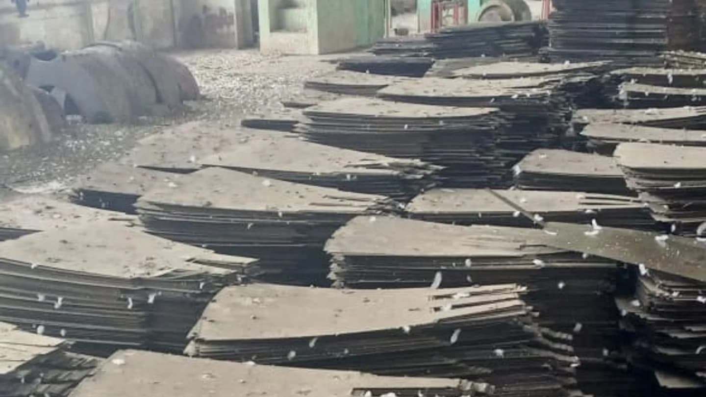 Stacked bundles of cut stainless steel plate on the turbine hall floor